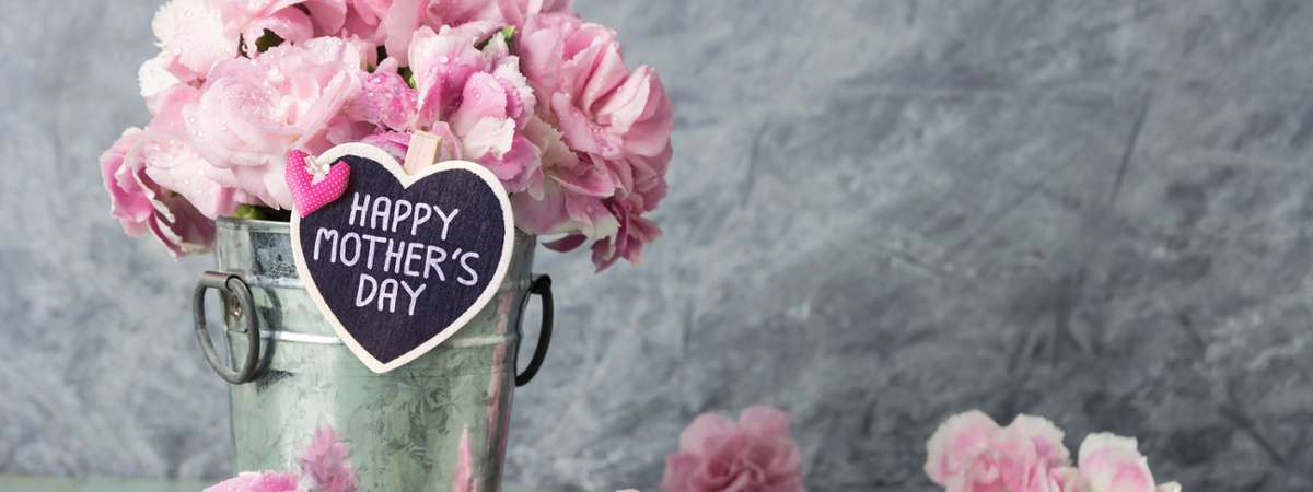 bucket with pink flowers with sign that says happy mother's day