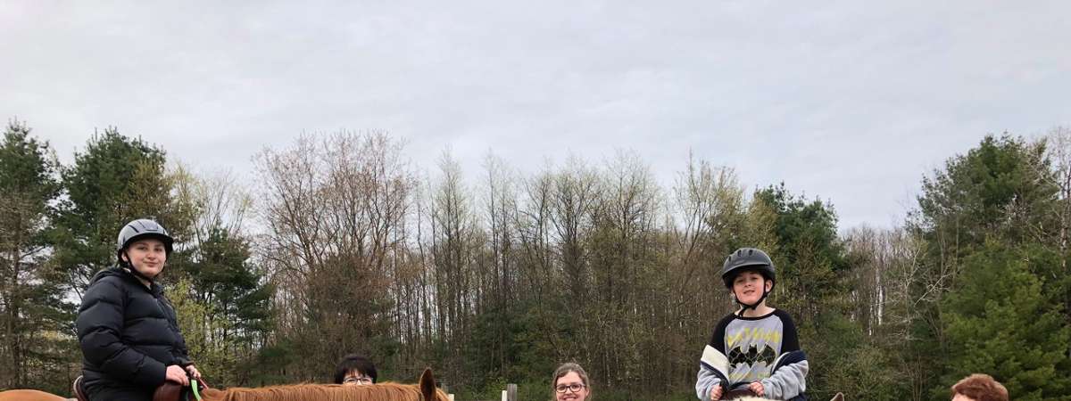 group of people near two horses