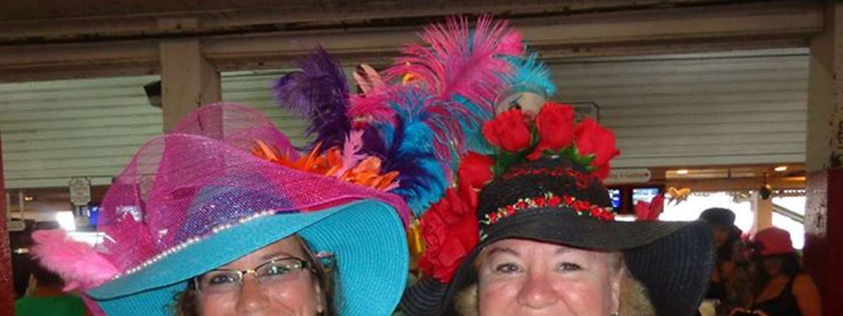 two women with colorful hats posing for the camera