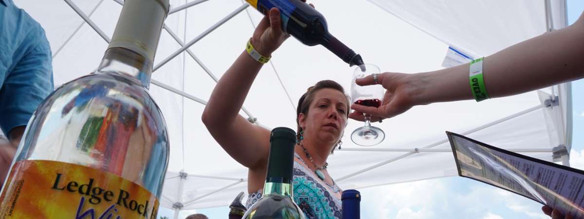 woman pouring a wine sample