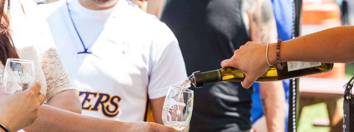 person pouring a wine sample