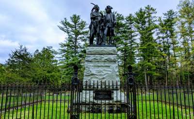 statue of native american and trapper