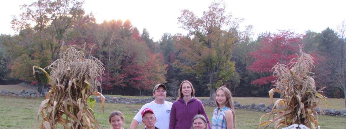 people posing near pumpkins