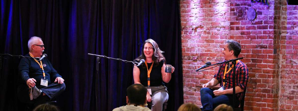 three people on stage at a book reading