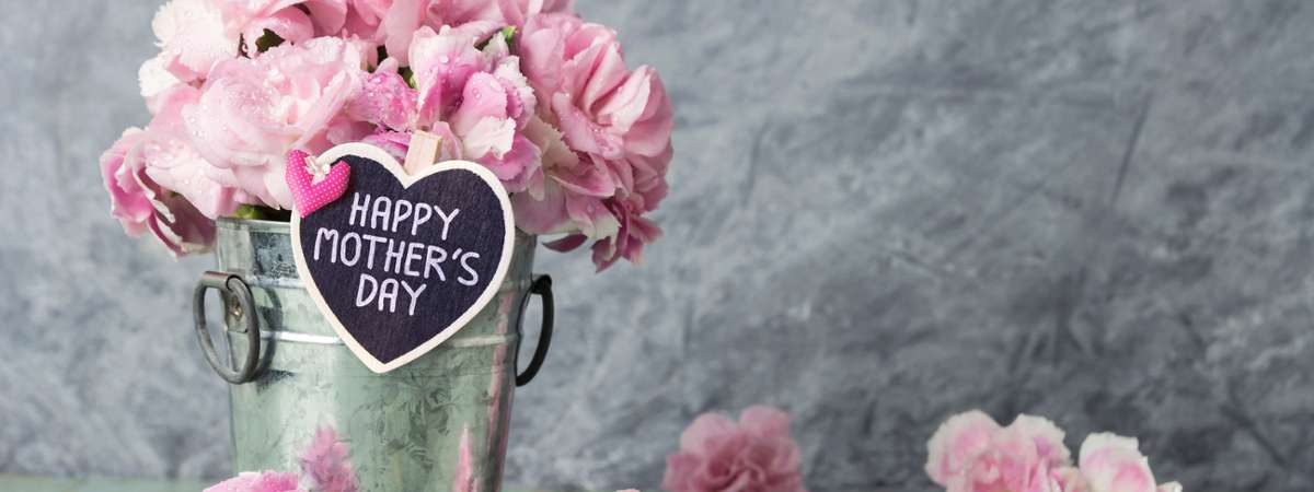 bucket of pink flowers with happy mother's day sign