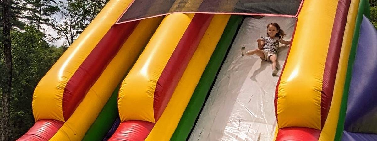 little girl on bounce house slide