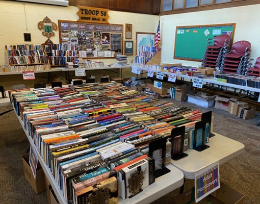stacks of books on white plastic tables