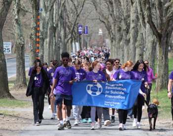 Large group of 670 walkers behind a banner with the logo for the American Foundation for Suicide Prevention.