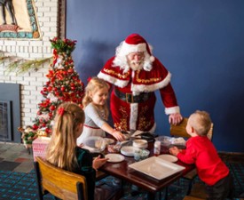 santa talking to kids at a table