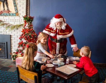 santa talking to kids at a table