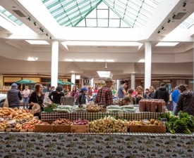 people shopping at an indoor farmers market