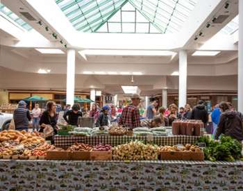 people shopping at an indoor farmers market