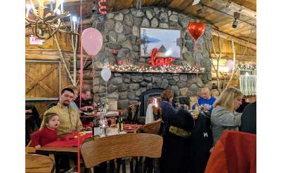 restaurant decorated for valentine's day, people eating by fire