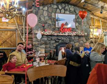 restaurant decorated for valentine's day, people eating by fire