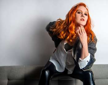 woman with red hair sitting on couch