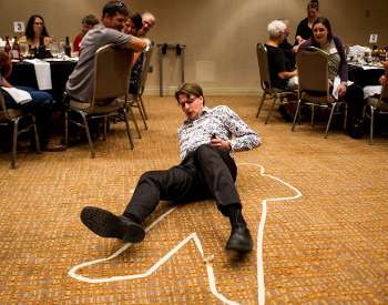 man laying on ground with crime scene tape around him