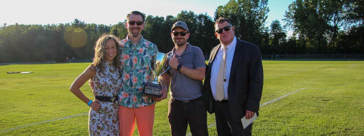 Croquet winners, four people standing in a field holding a trophy