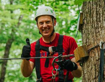 man on a zipline smiling