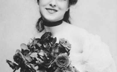 black and white old fashioned headshot of a woman holding flowers