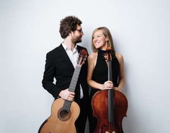 man with guitar poses with woman with cello