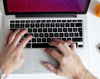 Overhead image of laptop, cellphone, keyboard