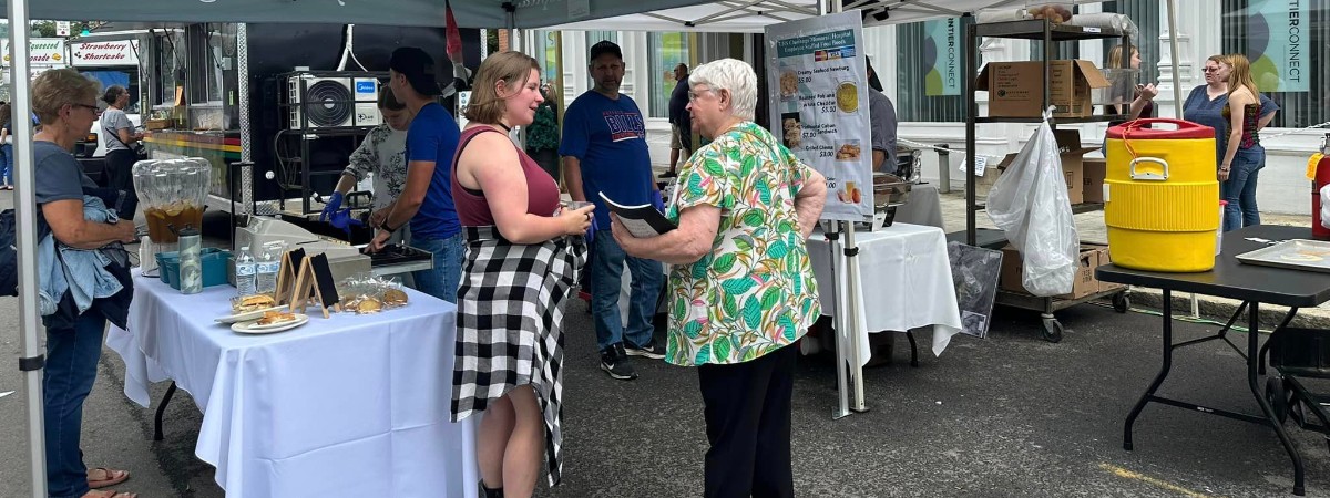 people outside a vendor tent