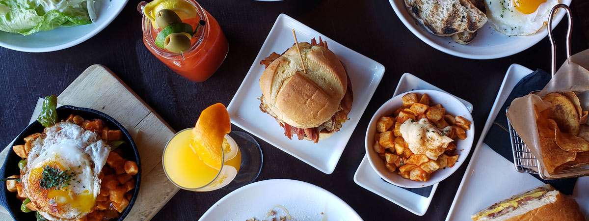 Brunch food items on plates along table top