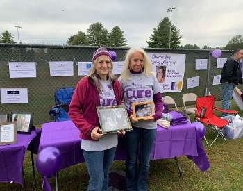 Donna Britton and Darlene Chorman participating in the Walk 2022 holding pictures of our Dad who died from CJD