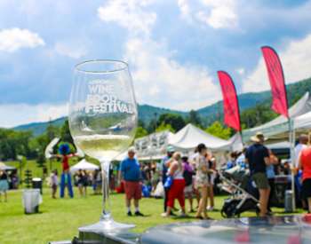 wine glass on a table near people at an outdoor festival