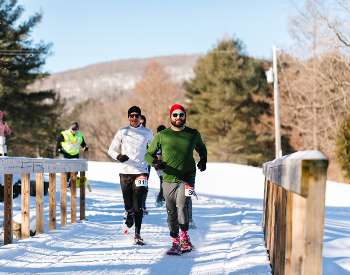 Snowshoe racers crossing bridge at beautiful Brookhaven Winter Park, photo by Erin Fortin Photography