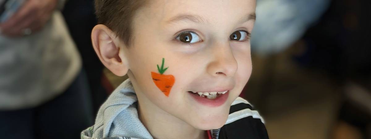 kid with carrot face painting