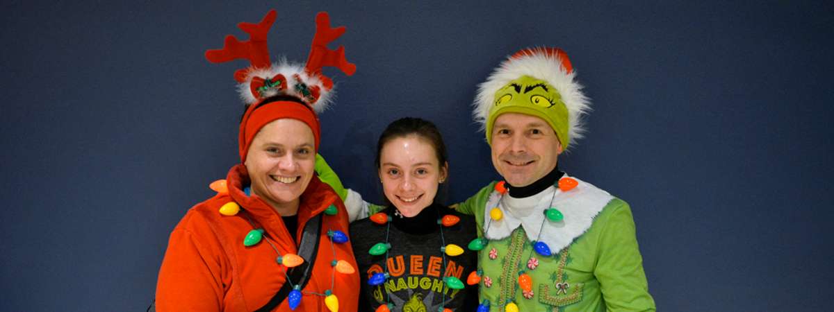three festive people in holiday outfits