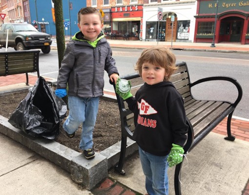 two little kids with trash bags