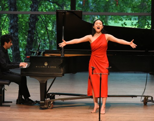 man at piano and woman singing on stage