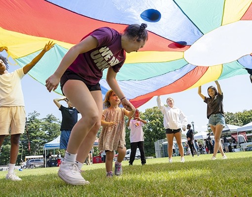 kids playing under colorful parachute