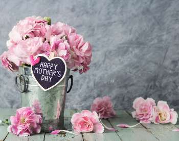 mother's day sign with pink flowers in pail