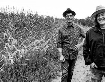 three musicians by cornfield