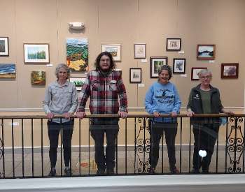 The art committee members with a sample of the work on display.