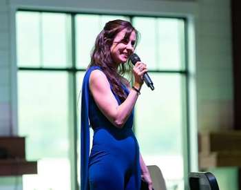 woman in blue dress with microphone