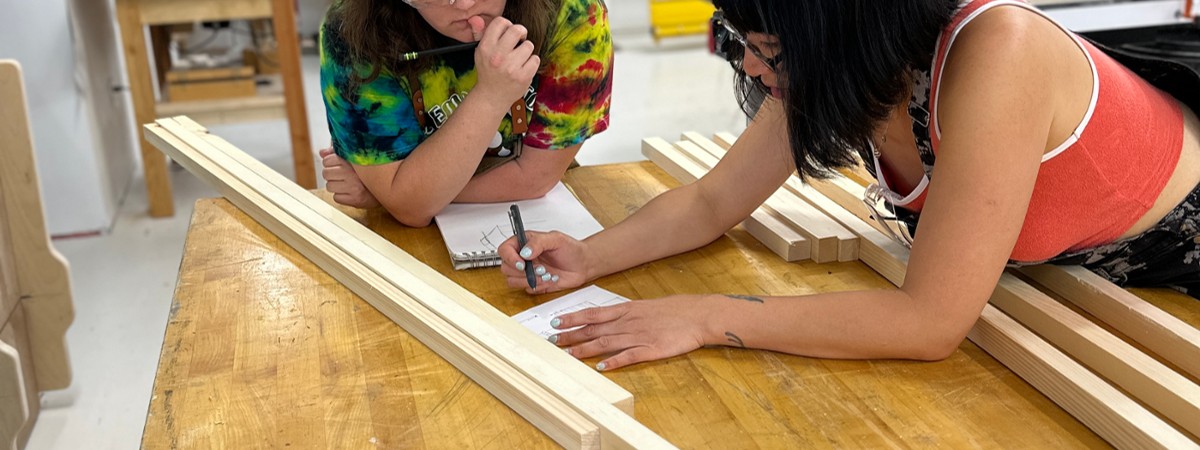 women brainstorm on a woodworking project