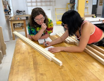 women brainstorm on a woodworking project