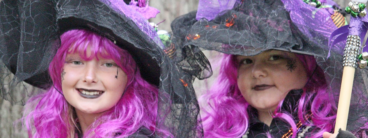 two young women dressed as witches with purple hair