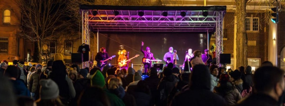 outdoor concert with musicians on stage and fans in crowd