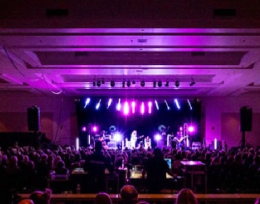 indoor performance with fans watching musicians on stage