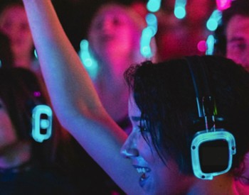 woman with headphones on listening to silent disco in a crowd