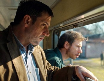 Two men looking out of a train window