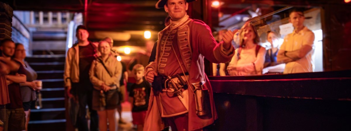 man in old soldier outfit giving a tour at nighttime