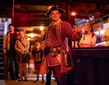 man in old soldier outfit giving a tour at nighttime