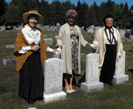 three women reenactors standing near graves