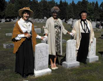 three women reenactors standing near graves